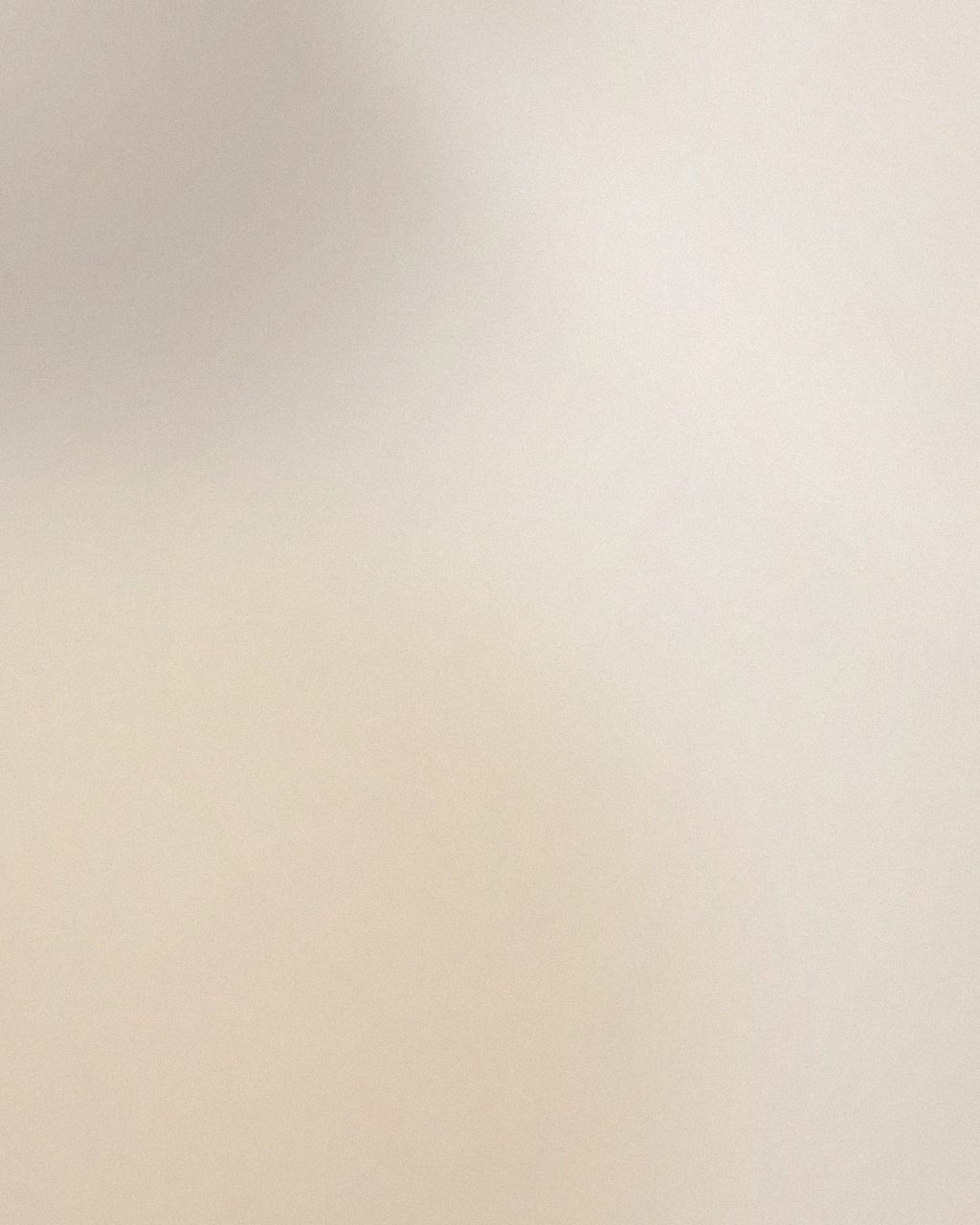 Mani e piedi appoggiati su una spugna color sabbia accanto a una ciotola in ceramica, visti dall’alto