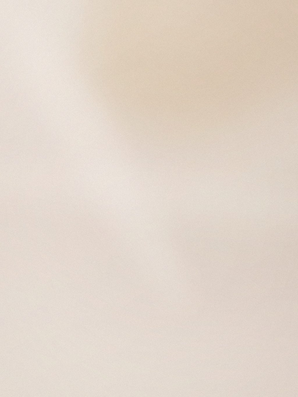 Braccia e spalle su un lenzuolo chiaro, luce diffusa e composizione minimale