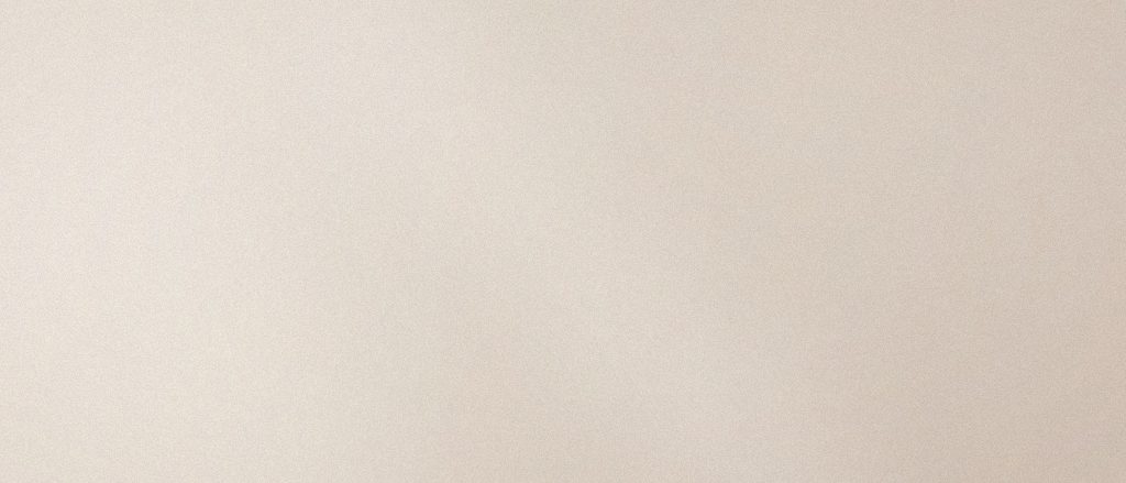 Manipolo per trattamenti estetici appoggiato su lino chiaro accanto a flaconi in vetro ambra, in luce morbida